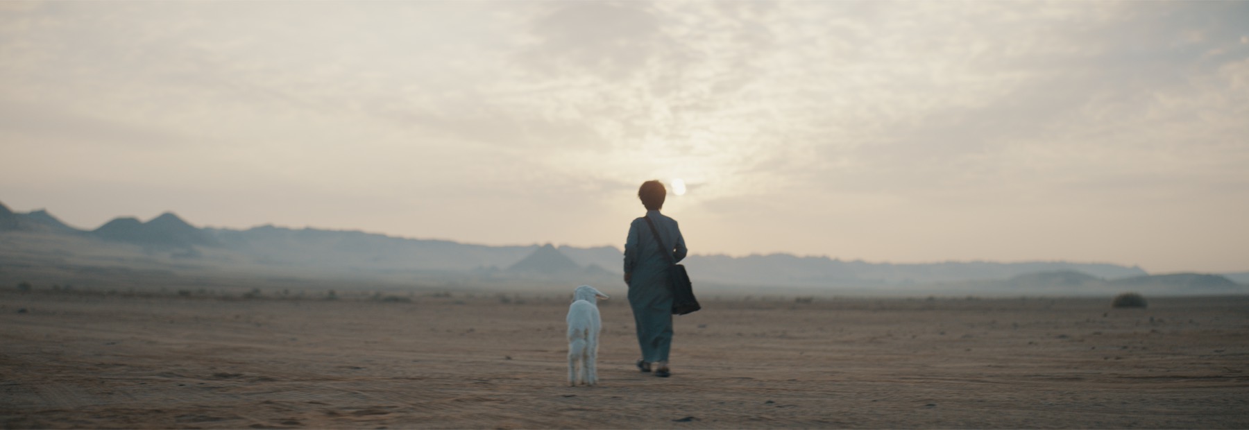 Abdulaziz Alqahtani walking with the lamb across the desert