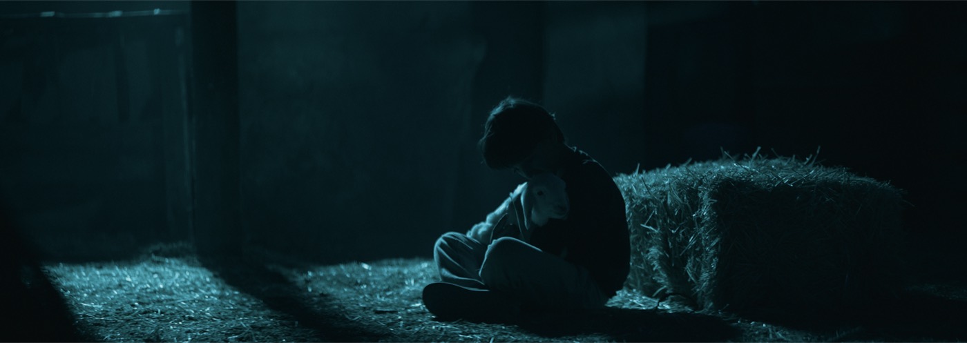 A boy embracing his lamb in The Lamb