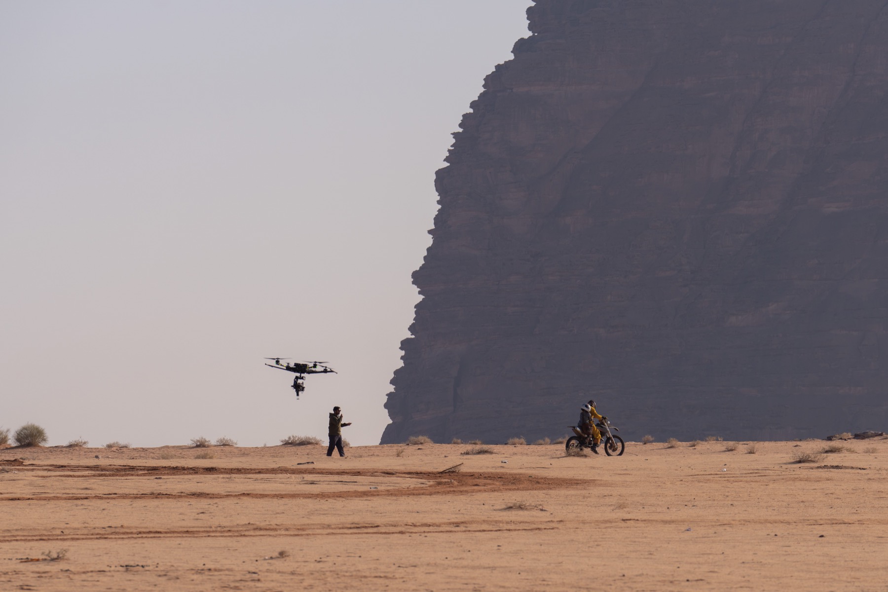 A drone camera follows a motorcycle across the Arabian desert during production of The Lamb